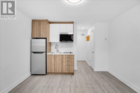 A kitchen with wooden cabinets and a refrigerator.