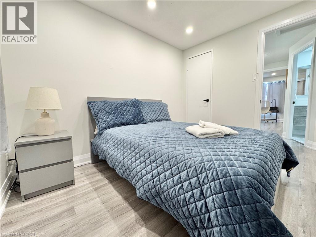 A bedroom with a bed, nightstand, and lamp.