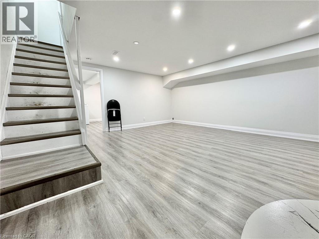 A spacious room with a staircase and a chair.