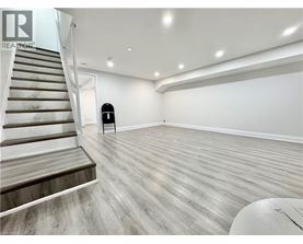 A spacious room with a staircase and a chair.