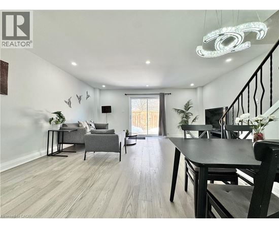A well-lit living room with a dining table and chairs.