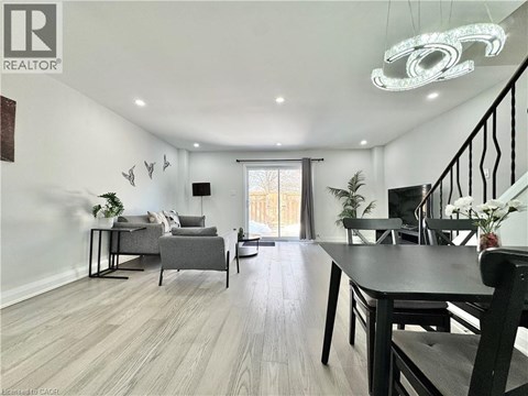 A well-lit living room with a dining table and chairs.