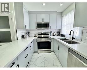 A modern kitchen with white cabinets and a marble countertop.