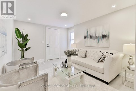 A white living room with a glass coffee table and a white sofa.