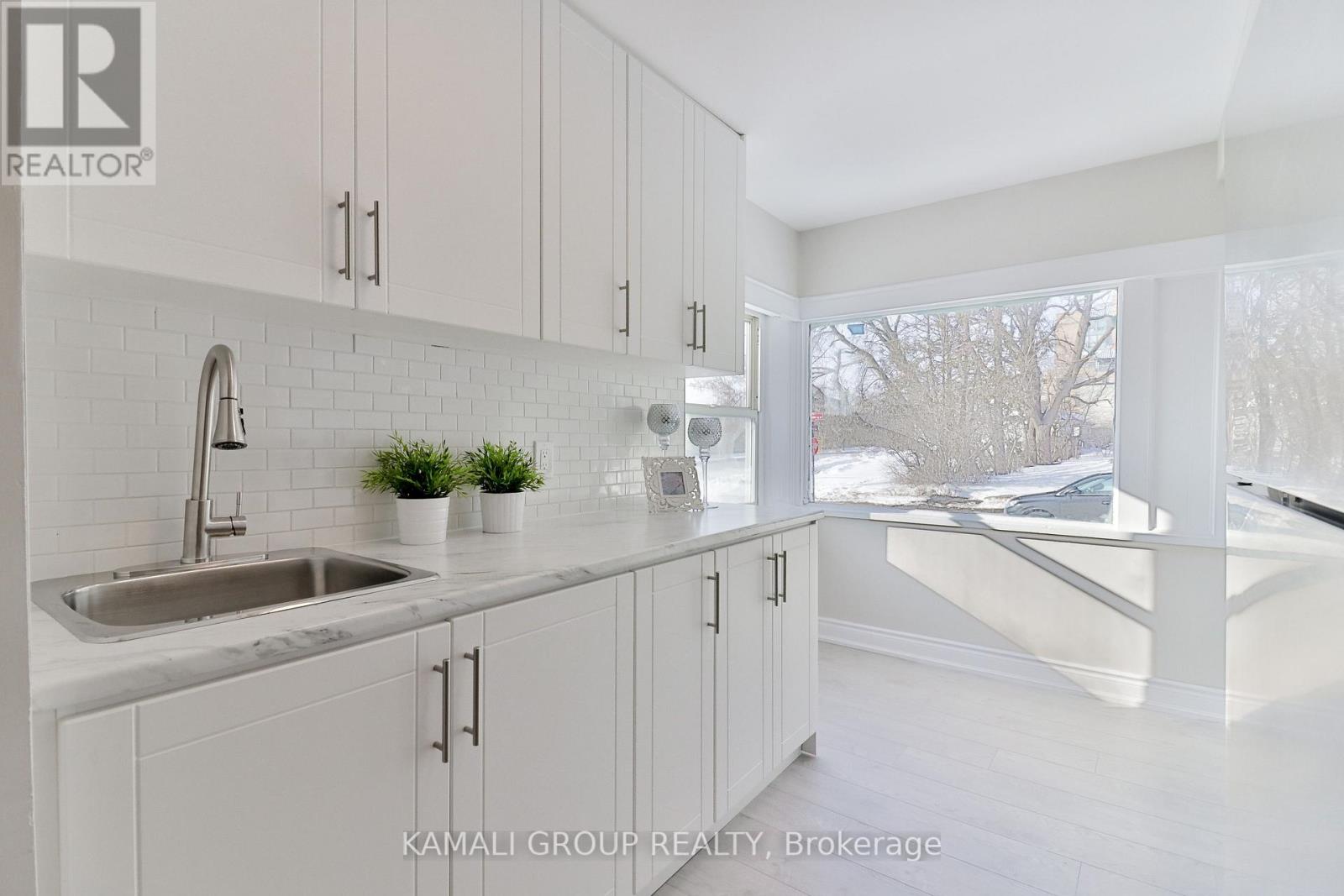 A kitchen with white cabinets and a sink.