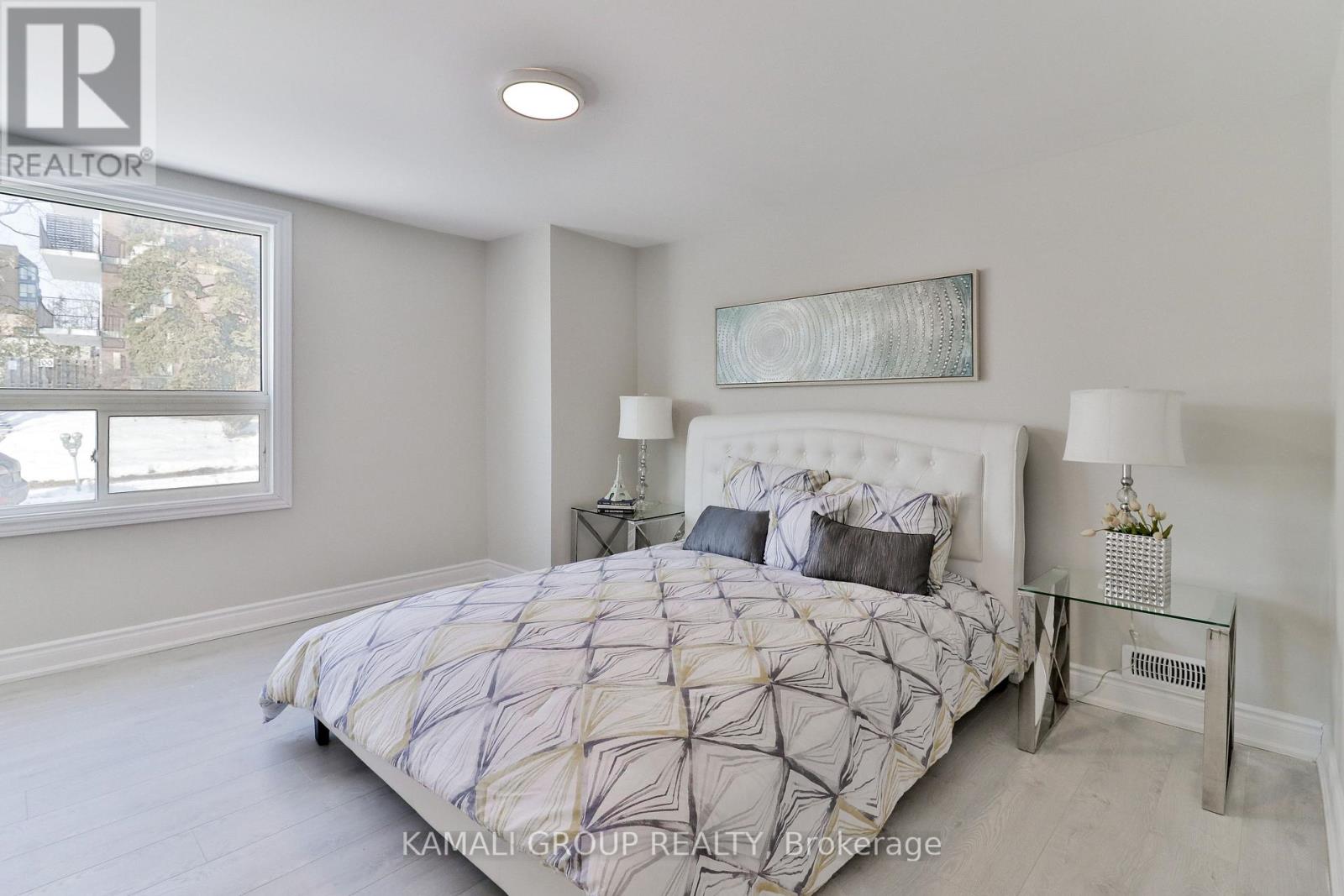 A bedroom with a large bed and a window overlooking a cityscape.