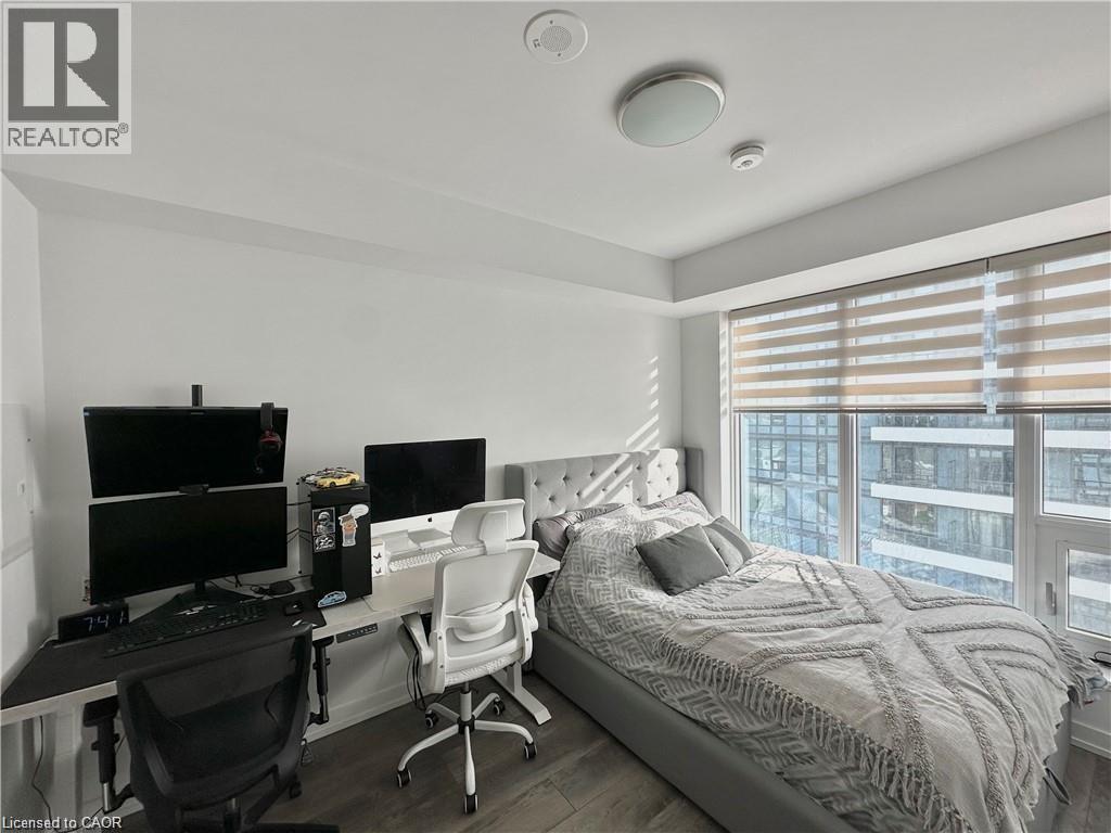 A bedroom with a bed, desk, and chair.