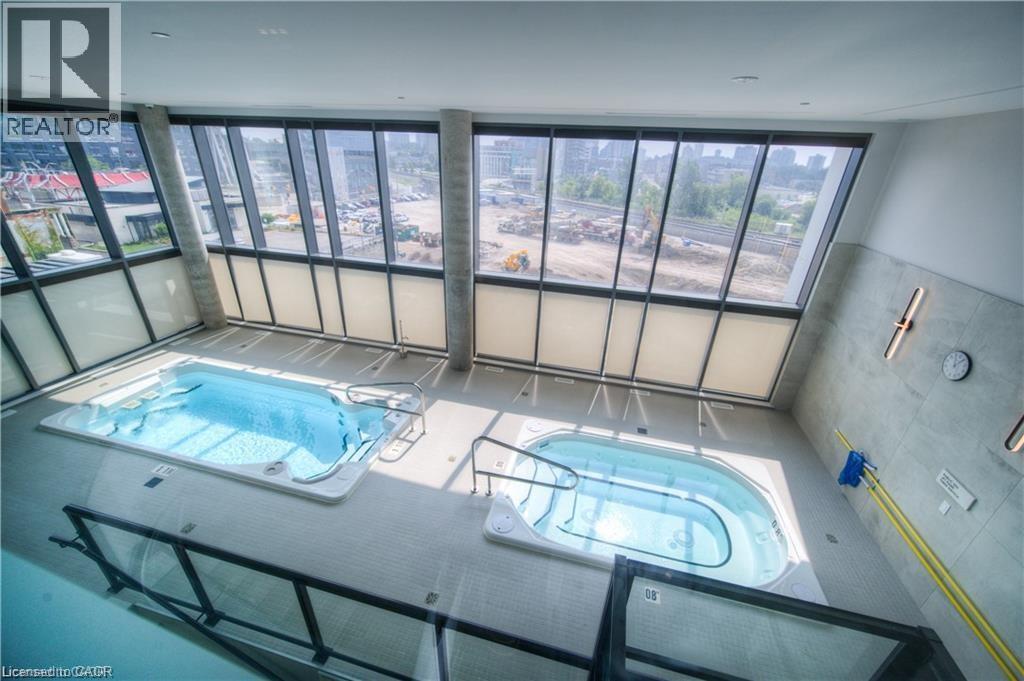 A swimming pool inside a building with a view of the city.