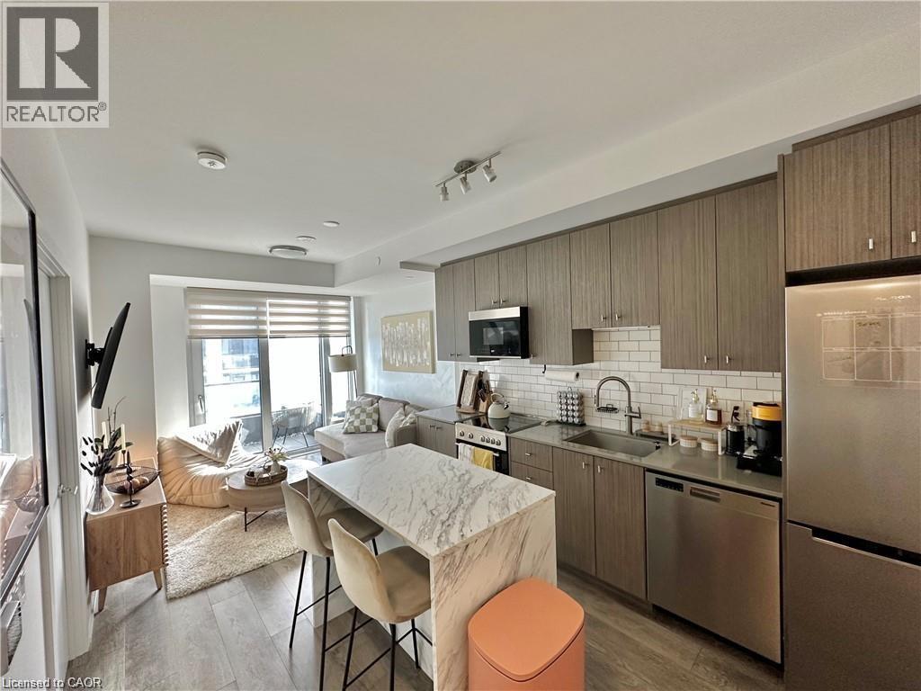 A modern kitchen with a marble table and stainless steel appliances.