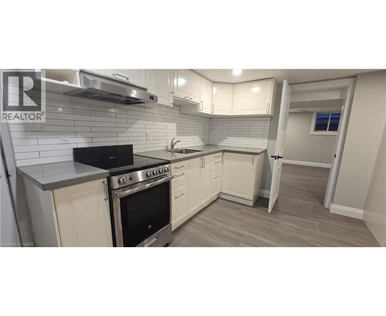 A kitchen with a black stove top oven and white cabinets.