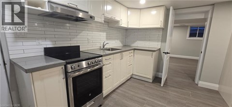 A kitchen with a black stove top oven and white cabinets.