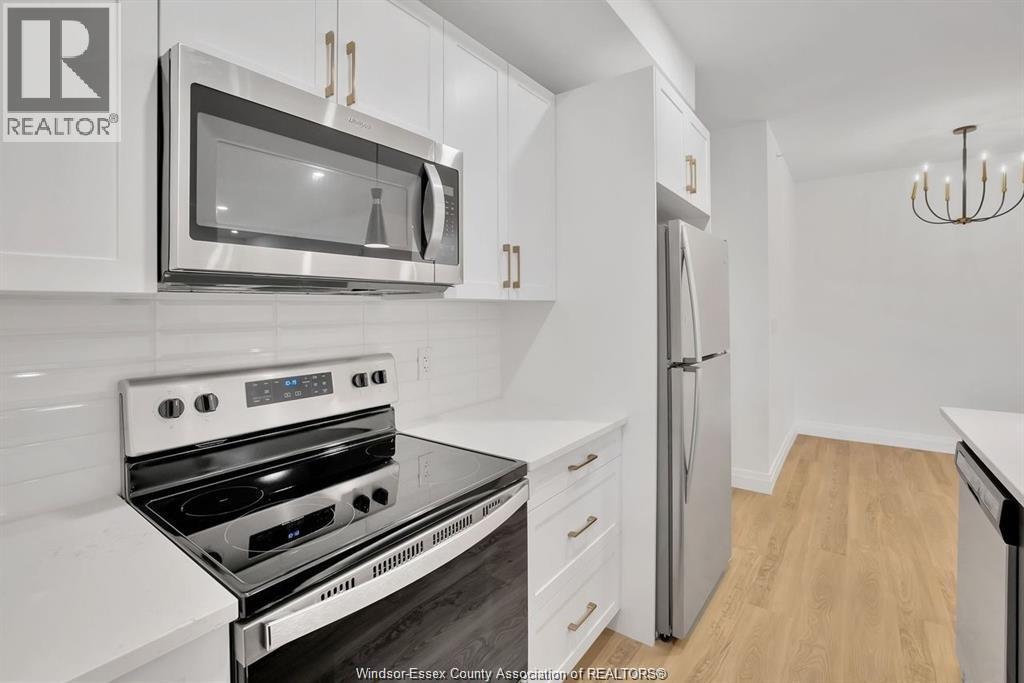A modern kitchen with a stainless steel stove and white cabinets.