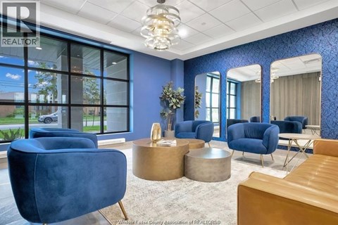 A living room with blue chairs and a wooden table.