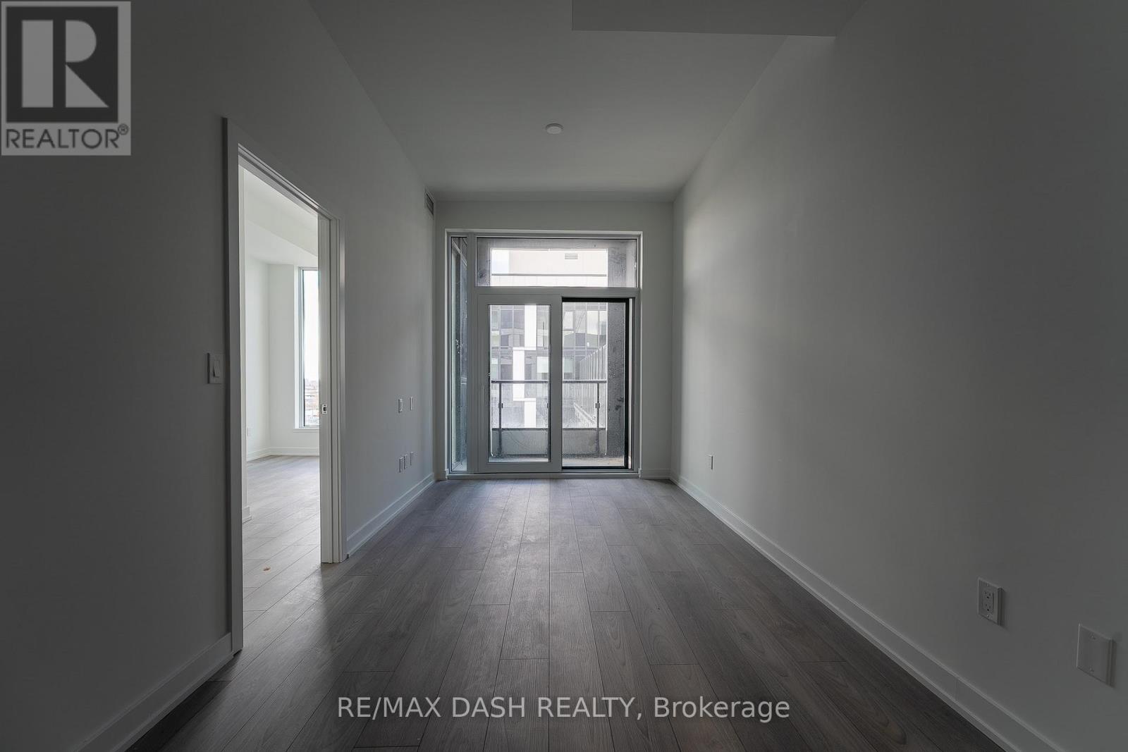 A spacious room with a door leading to a balcony.