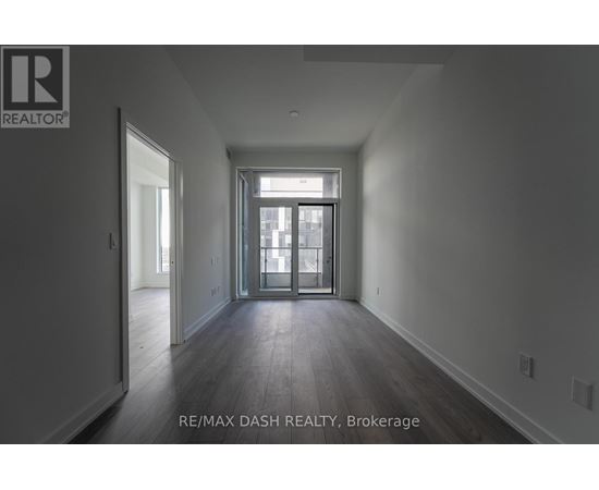 A spacious room with a door leading to a balcony.