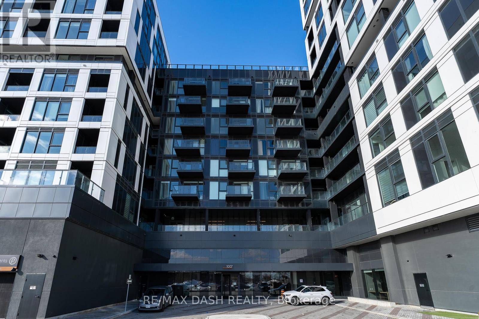 A modern building with the sign RE/MAX DASH REALTY-BROKERED in front of it.