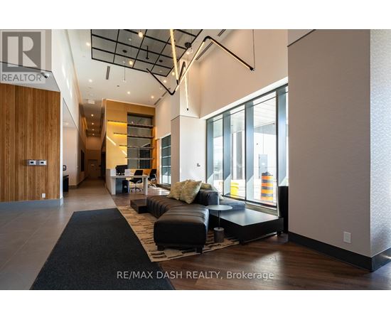 A modern living room with a black rug and a black couch.
