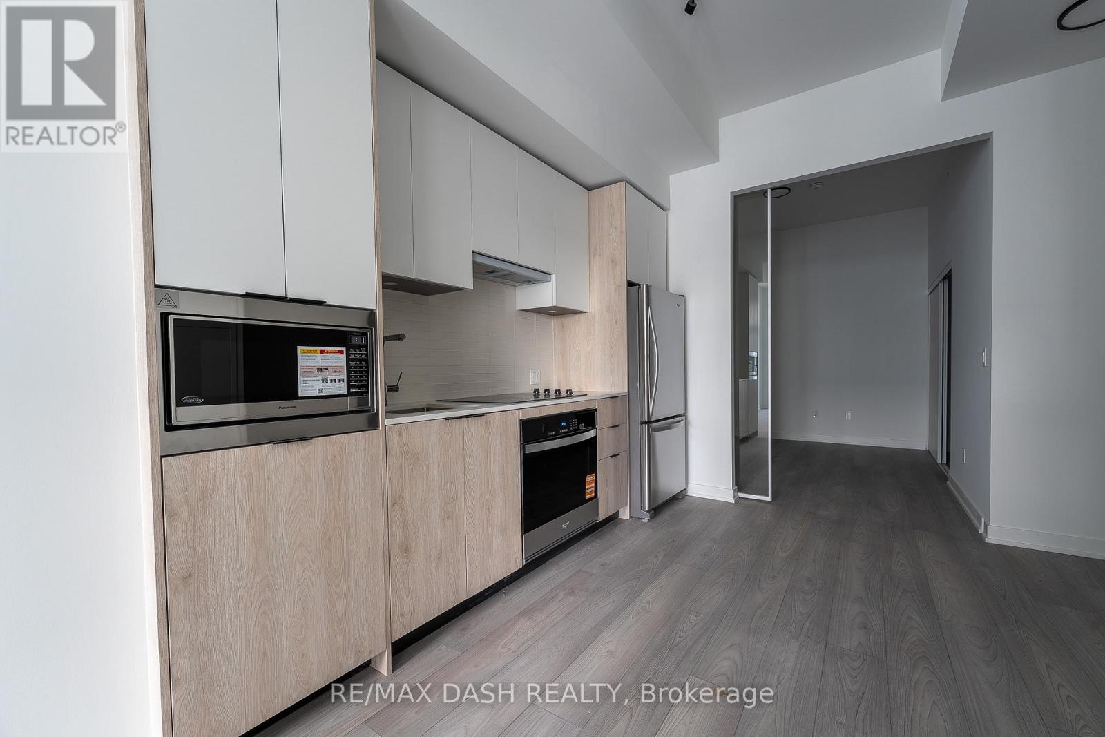 A modern kitchen with wooden cabinets and stainless steel appliances.