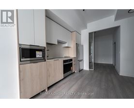 A modern kitchen with wooden cabinets and stainless steel appliances.