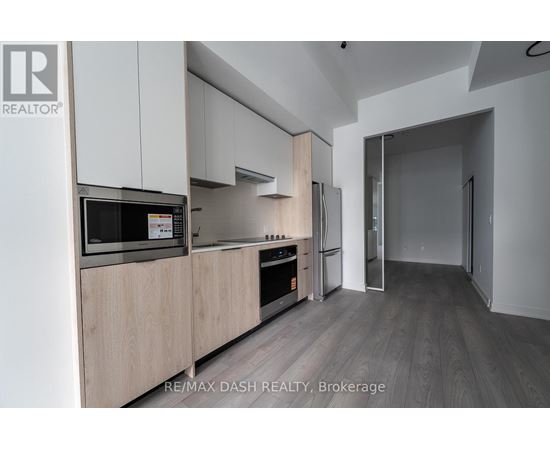 A modern kitchen with wooden cabinets and stainless steel appliances.