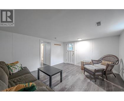 A living room with a grey couch and a glass coffee table.