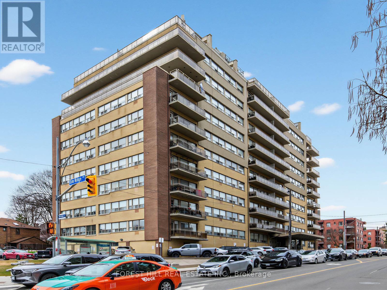 A tall apartment building with the words "FOREST HILL REAL ESTATE" on the front.