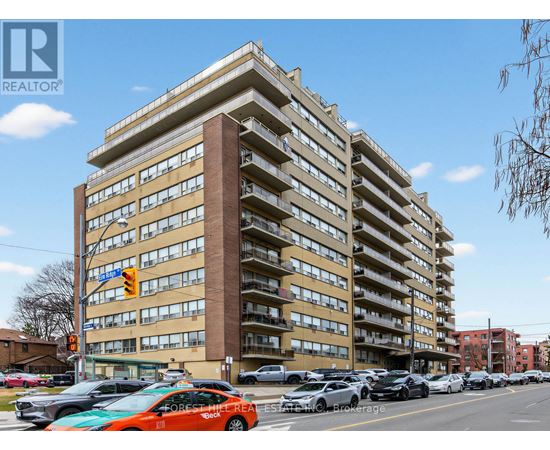 A tall apartment building with the words "FOREST HILL REAL ESTATE" on the front.