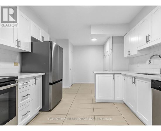 A kitchen with white cabinets and a black refrigerator.