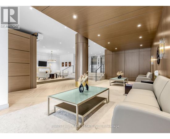 A modern living room with a glass coffee table and a white sofa.