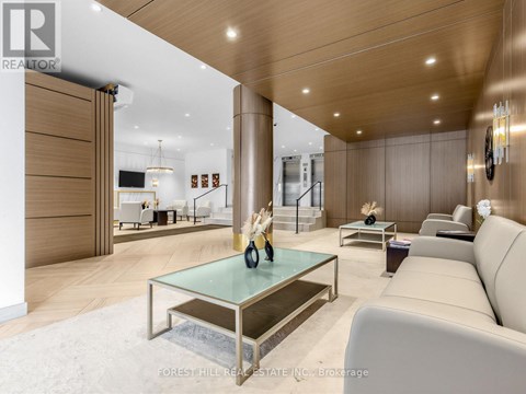 A modern living room with a glass coffee table and a white sofa.