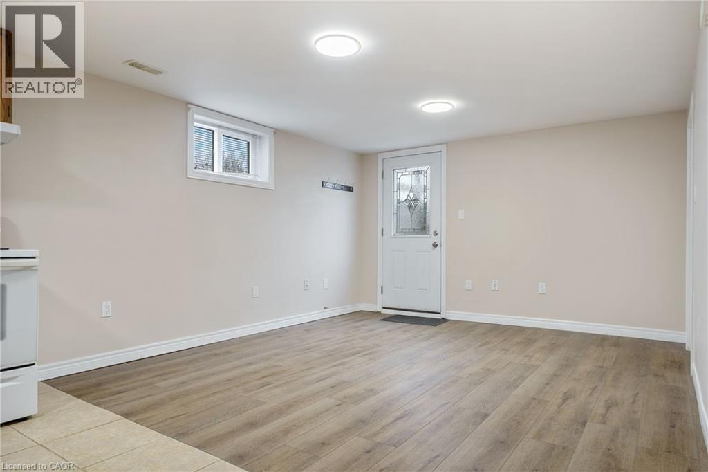 A spacious room with wooden flooring and a white door.