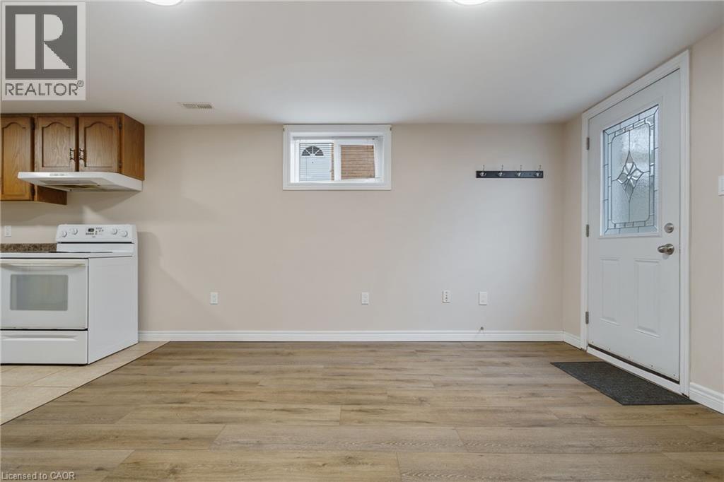 A kitchen with a white stove top oven and wooden cabinets.