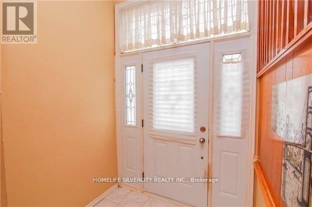 A white door with a glass window is in a room with orange walls.