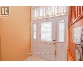 A white door with a glass window is in a room with orange walls.