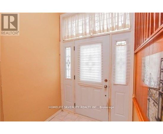 A white door with a glass window is in a room with orange walls.