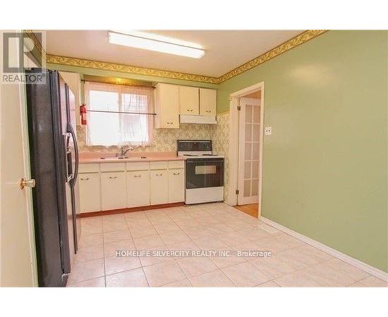 A kitchen with green walls and white cabinets.
