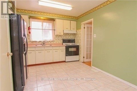 A kitchen with green walls and white cabinets.