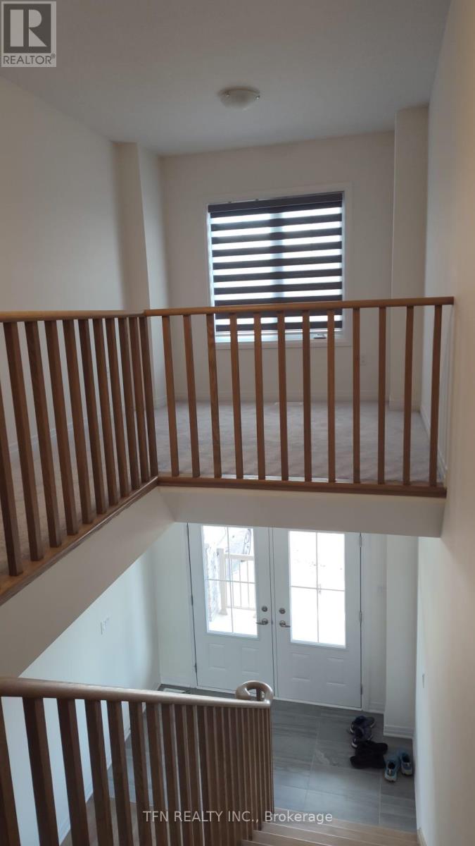A staircase with wooden railings leads to a door with a window above it.