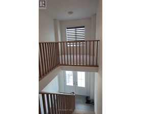 A staircase with wooden railings leads to a door with a window above it.