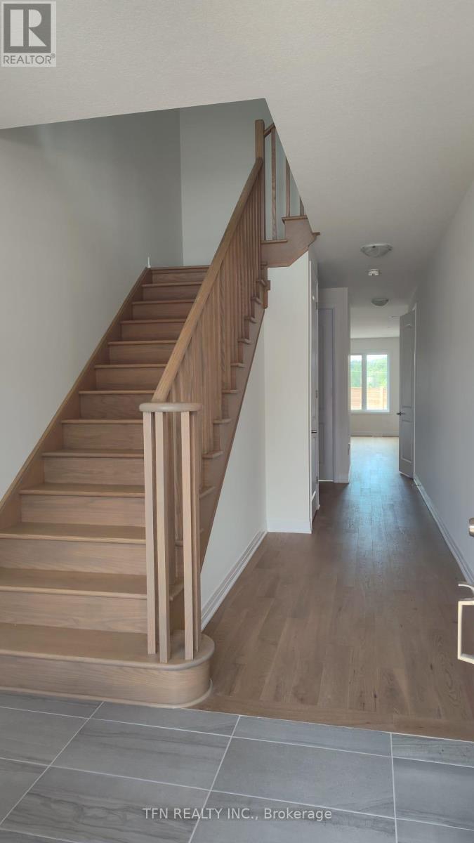 A wooden staircase with a metal railing leads to a second floor.