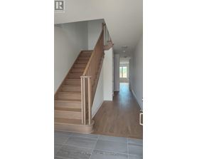 A wooden staircase with a metal railing leads to a second floor.