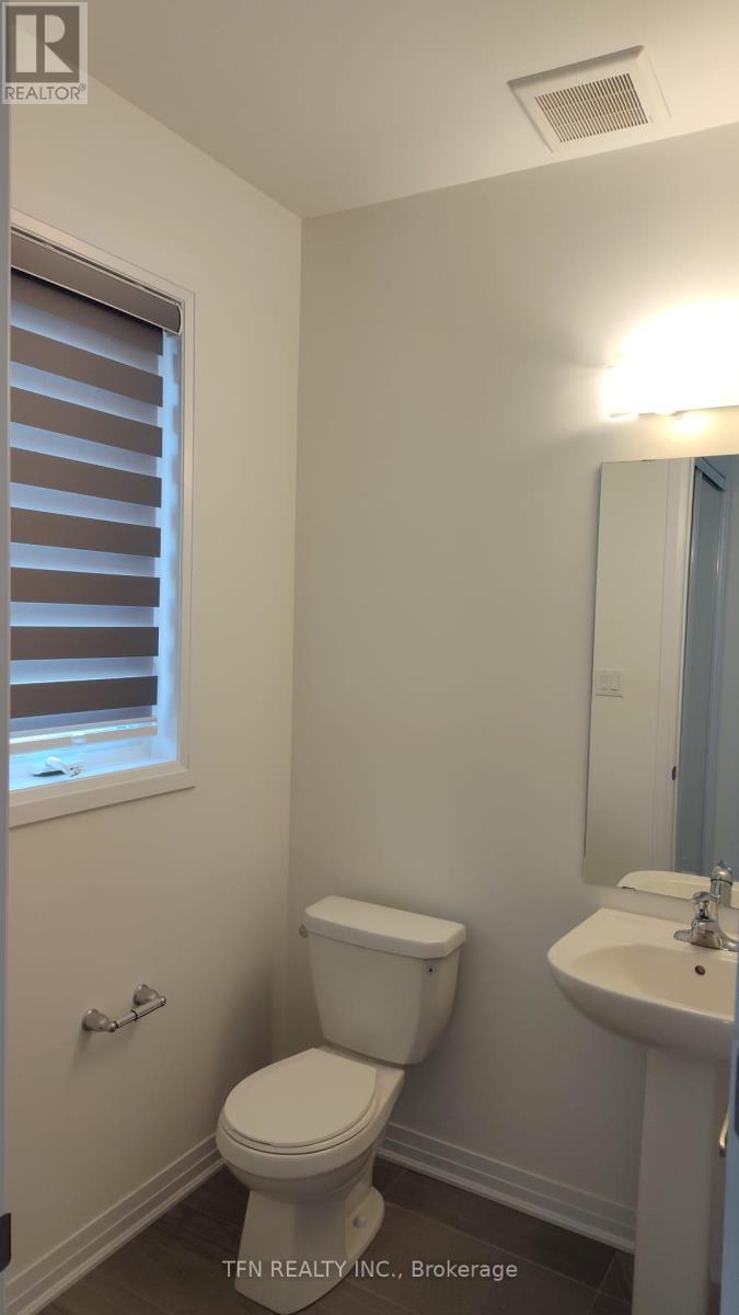 A white toilet sits next to a sink in a small bathroom.
