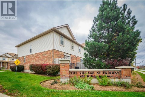 A sign for "The Village at Fairway" is in front of a house.