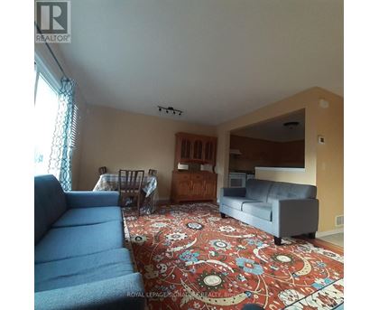 A living room with a blue couch and a rug with a floral pattern.