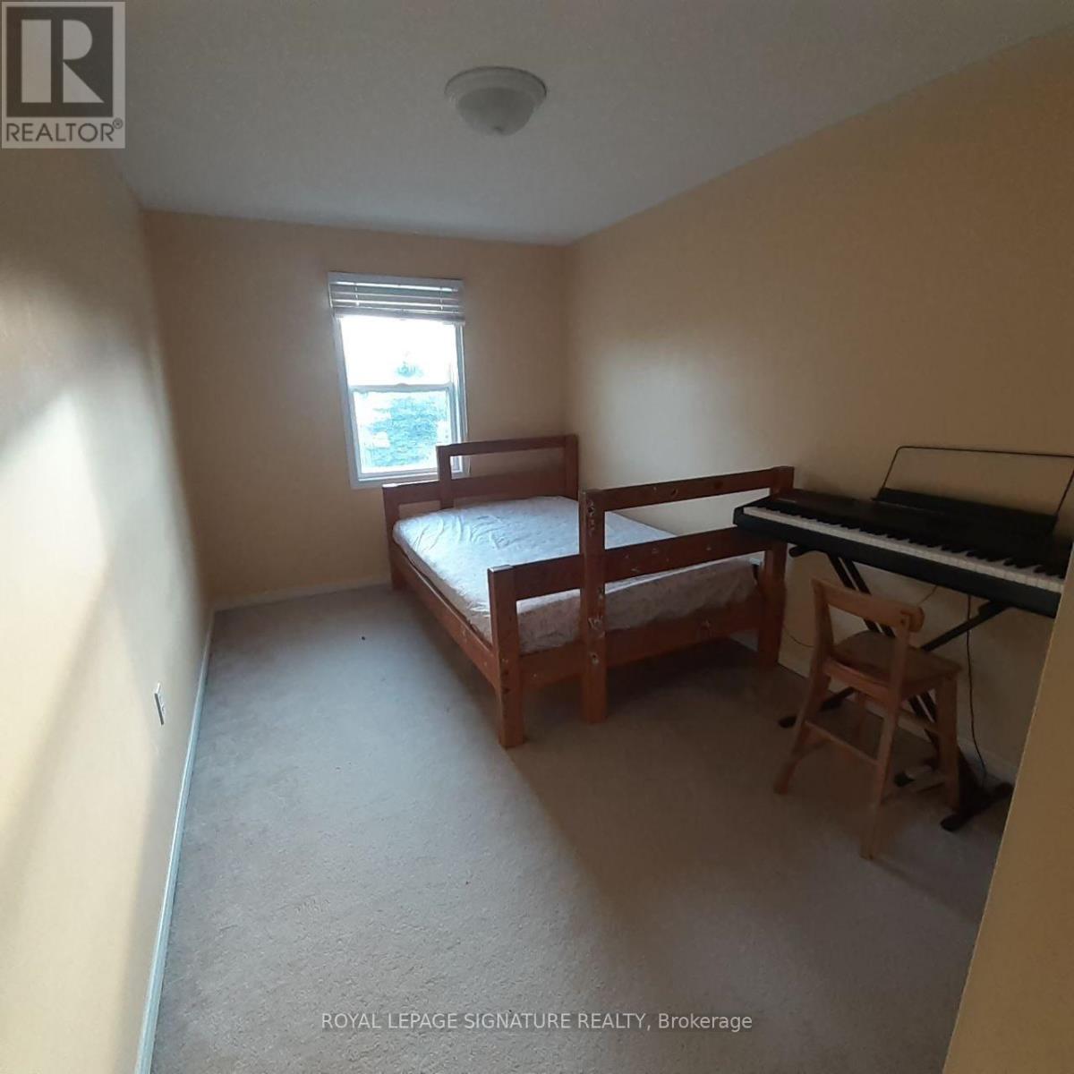 A bedroom with a bed, chair, and piano.