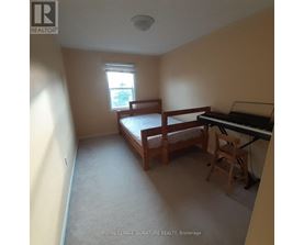 A bedroom with a bed, chair, and piano.