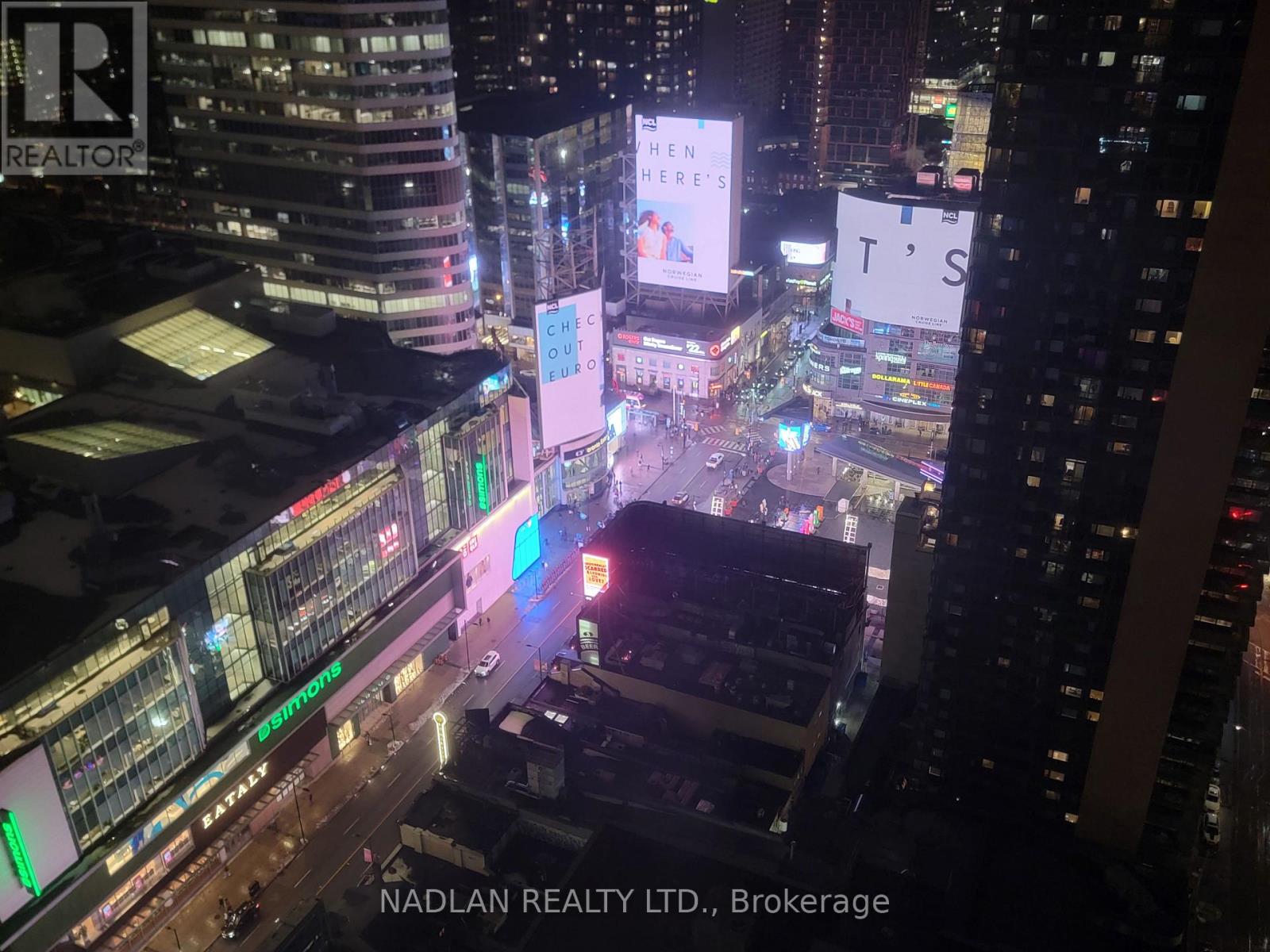 A cityscape at night with the text "NADLAN REALTY LTD., Brokerage" visible.