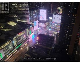 A cityscape at night with the text "NADLAN REALTY LTD., Brokerage" visible.