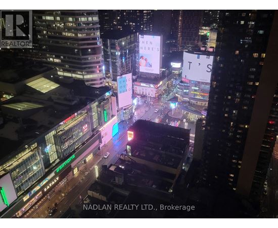 A cityscape at night with the text "NADLAN REALTY LTD., Brokerage" visible.