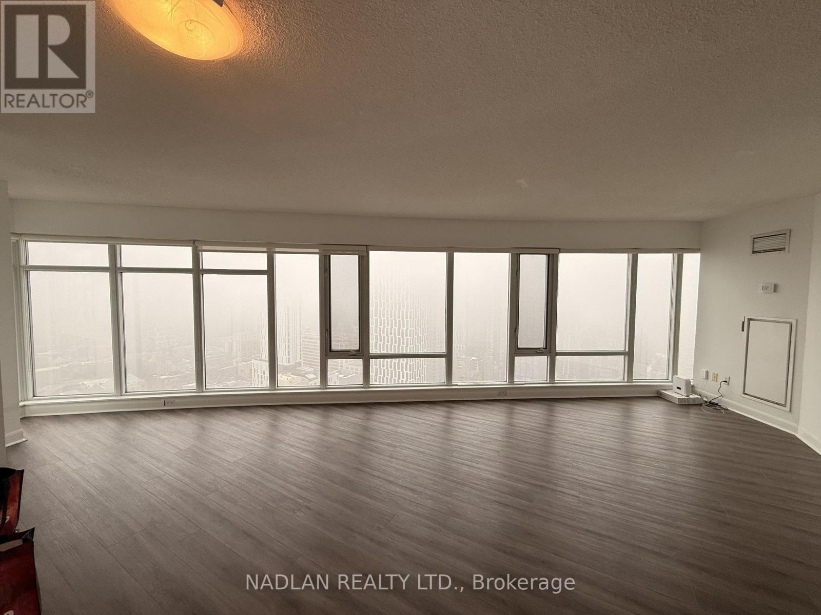 A room with a large window and wooden flooring.